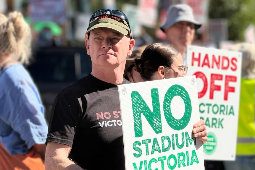 Campbell Newman holds a sign that says: "No stadium".
