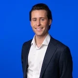 A person standing against a blue background.