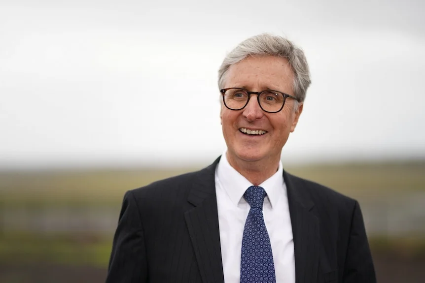 Simon Hickey wearing glasses and a suit