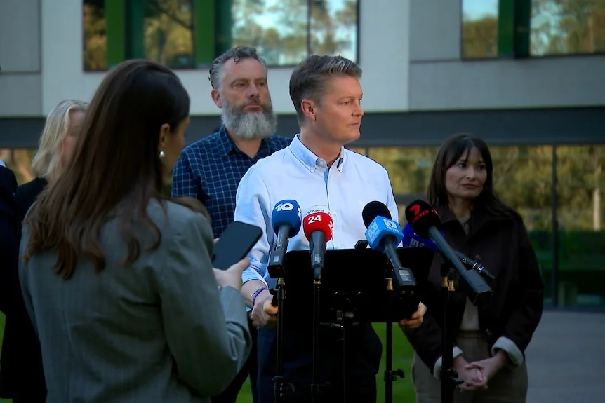 Ben Carroll addresses the media with wife Fiona by his side.