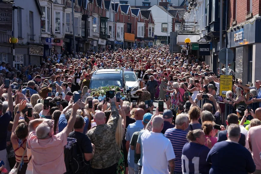 Fans crowd the hearse carrying pop legend Bonnie Tyler as it makes its way to her Welsh hometown.