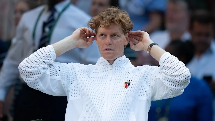 Jannik Sinner sitting courtside after winning the Wimbledon final.