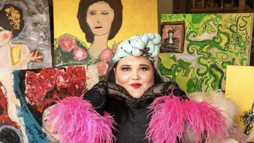 A woman wearing a bright pink feather boa.