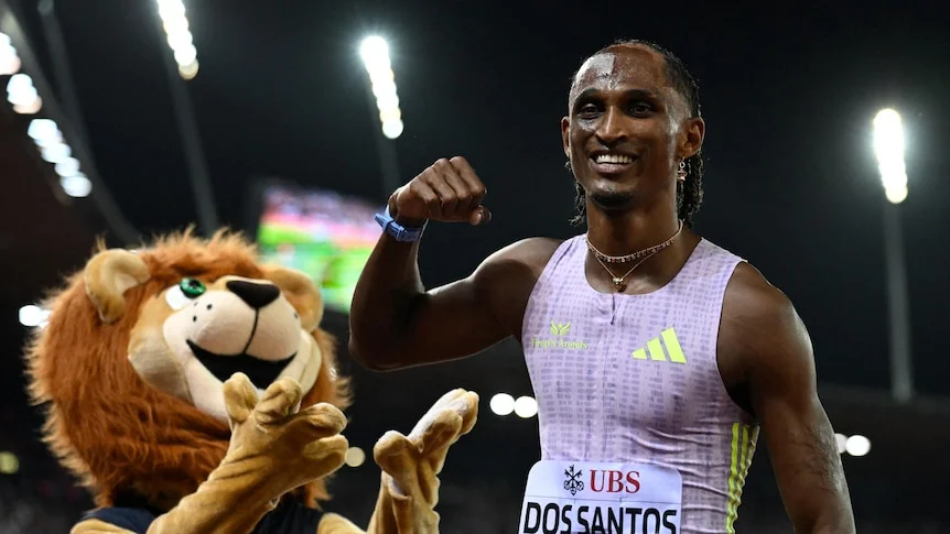 Alison dos Santos poses with a mascot after winning the men's 400m hurdles final.