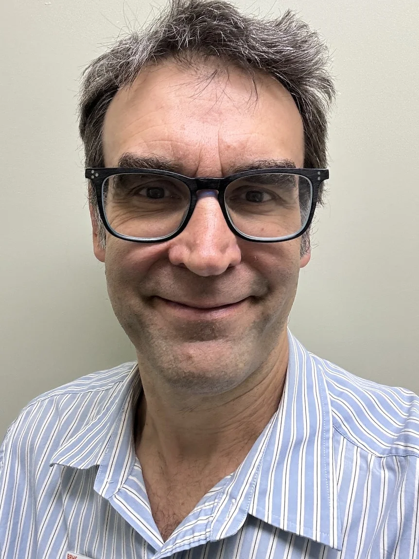 A man with grey hair smiling.