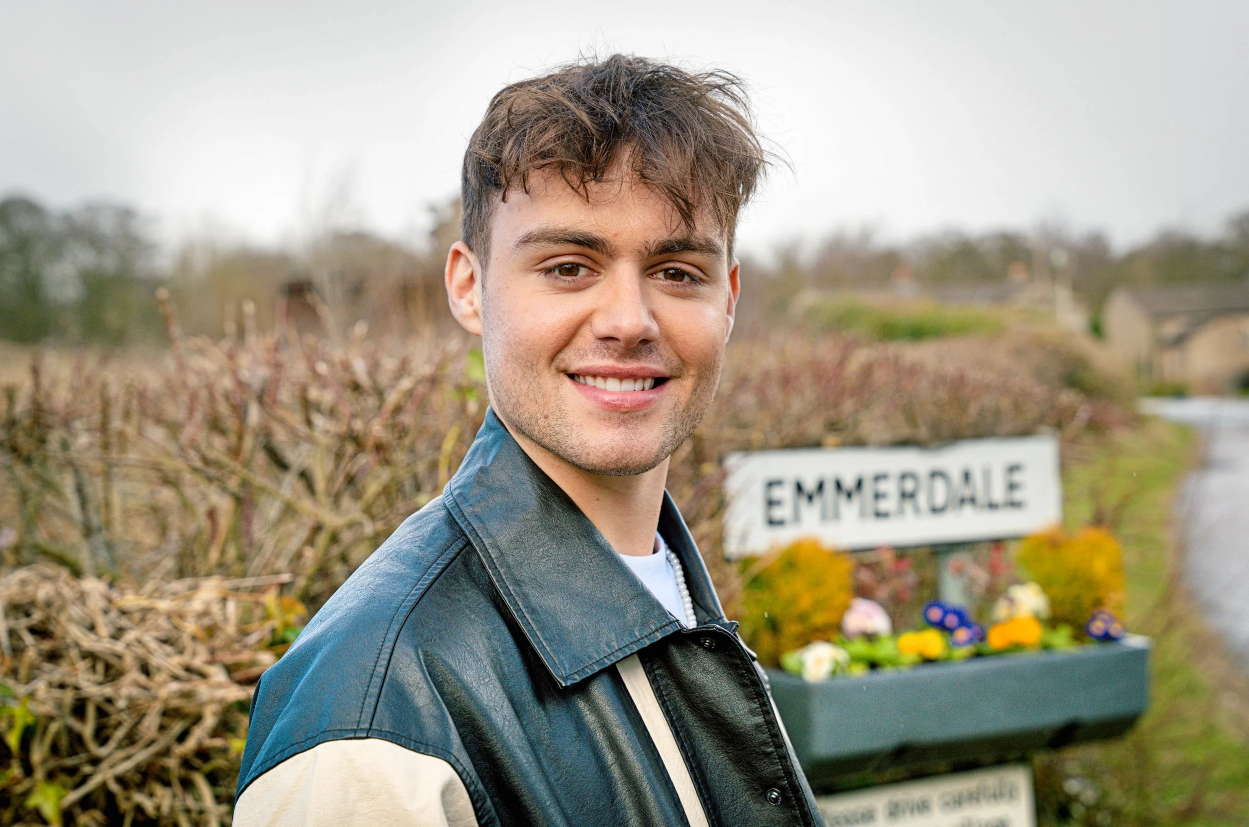 Bradley Riches stood in front of Emmerdale sign
