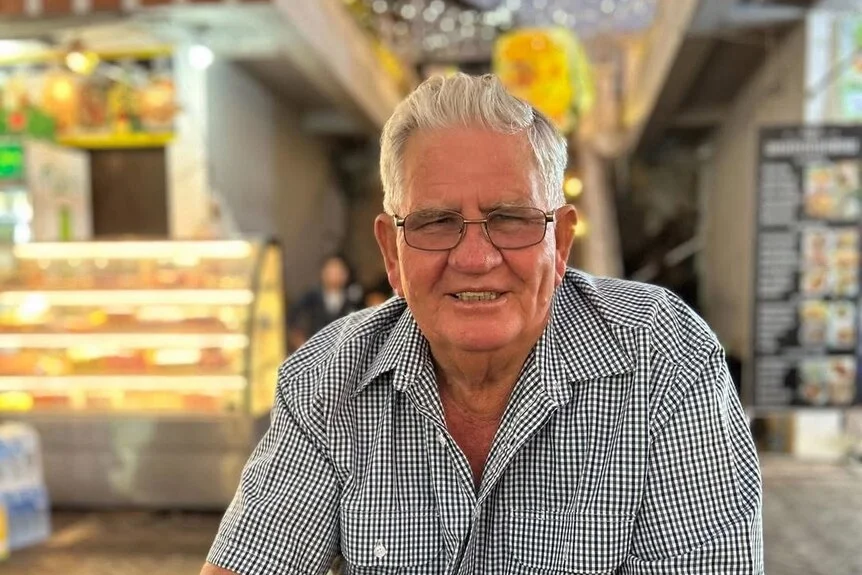 An elderly man smiling at the camera.