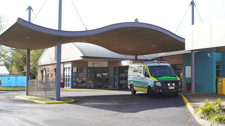 An ambulance sits out the front of a hospital emergency entry.