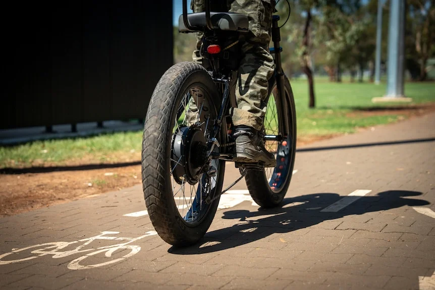A bike with large tyres rides along a public bike path