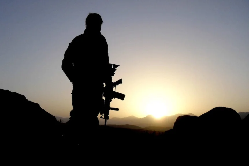 A silhouette of a soldier against the sun