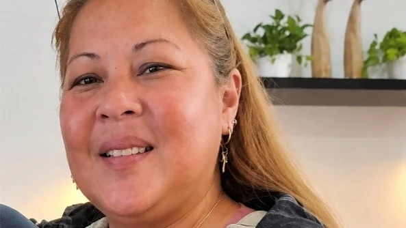 a woman with long brown hair smiles at the camera