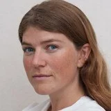 A profile image of a young woman with long, brown hair.