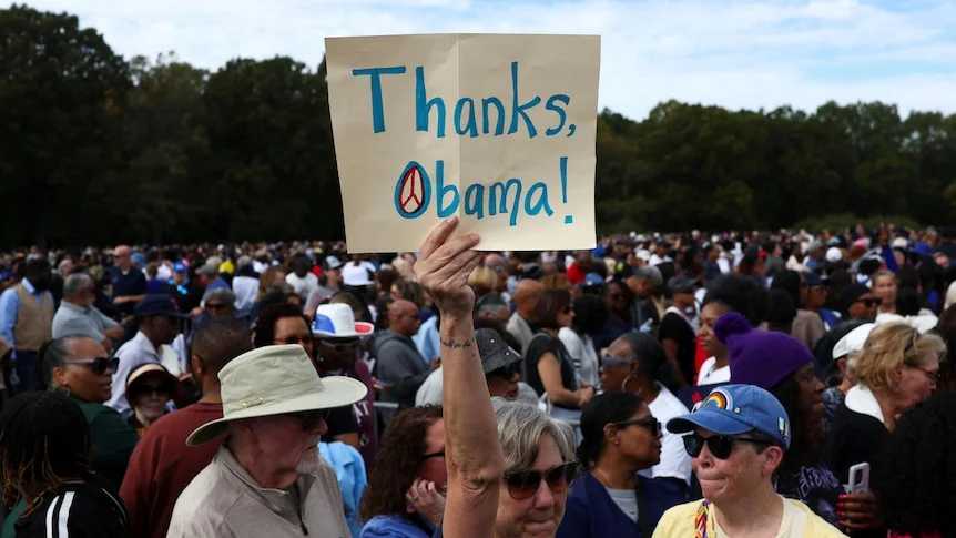 A Democrat supporter holds up a "Thanks, Obama" sign in a rally crowd
