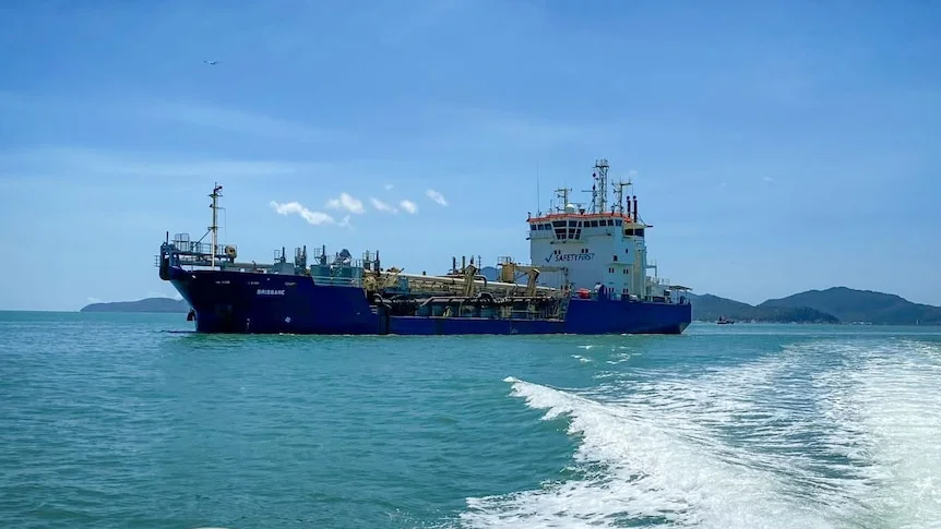 A large ship on open waters under blue skies.