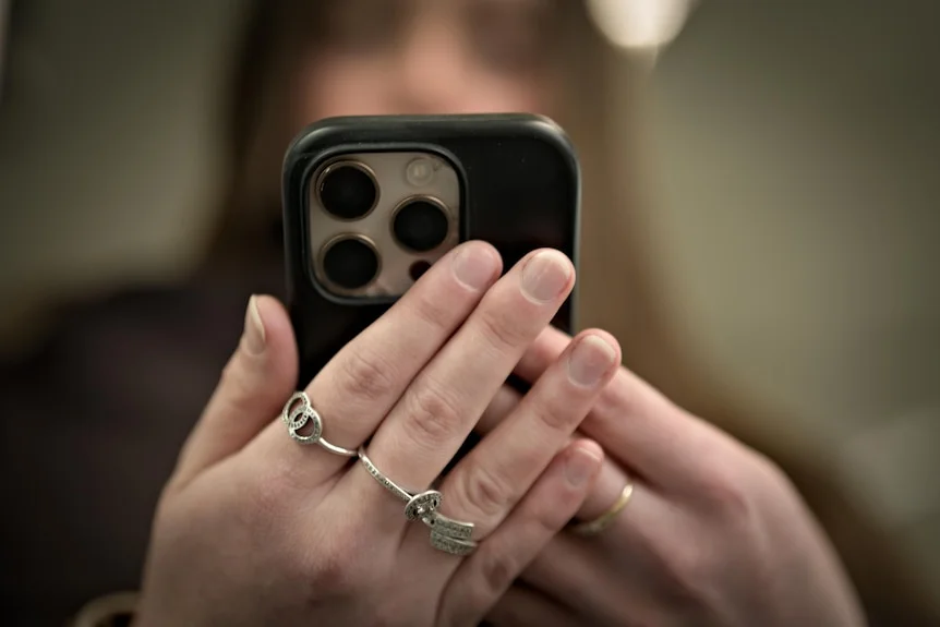 An unidentified young woman looks at her mobile phone.