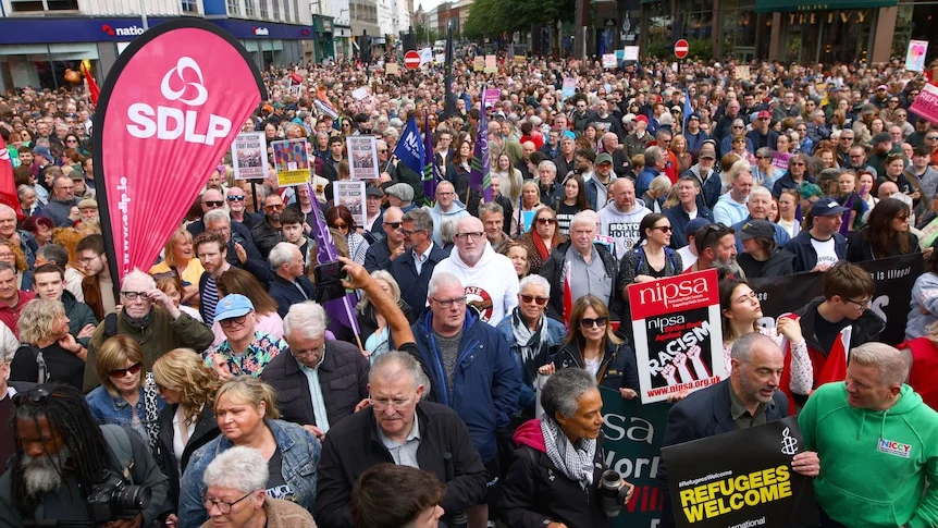 A large crowd of people gather at a rally in central Belfast.