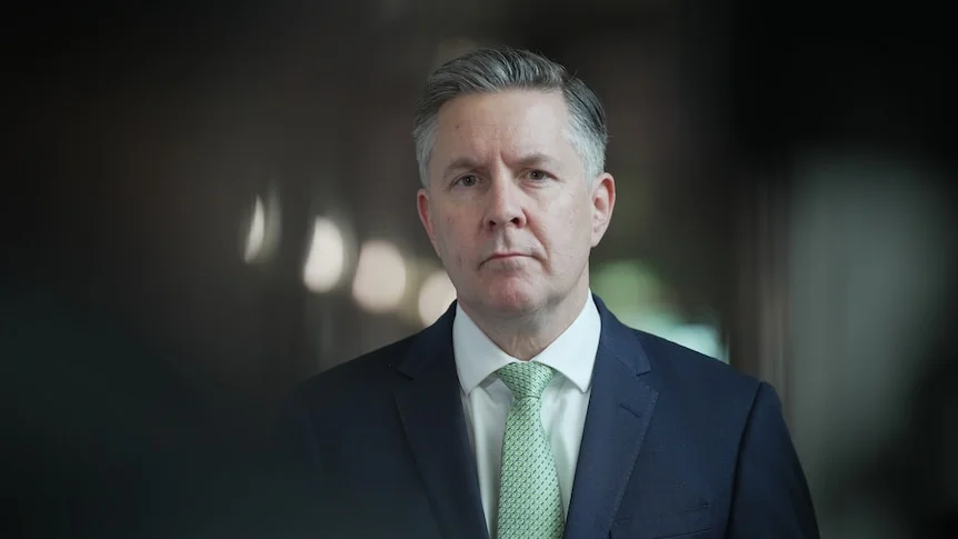 Mark Butler standing in a corridor in a suit.