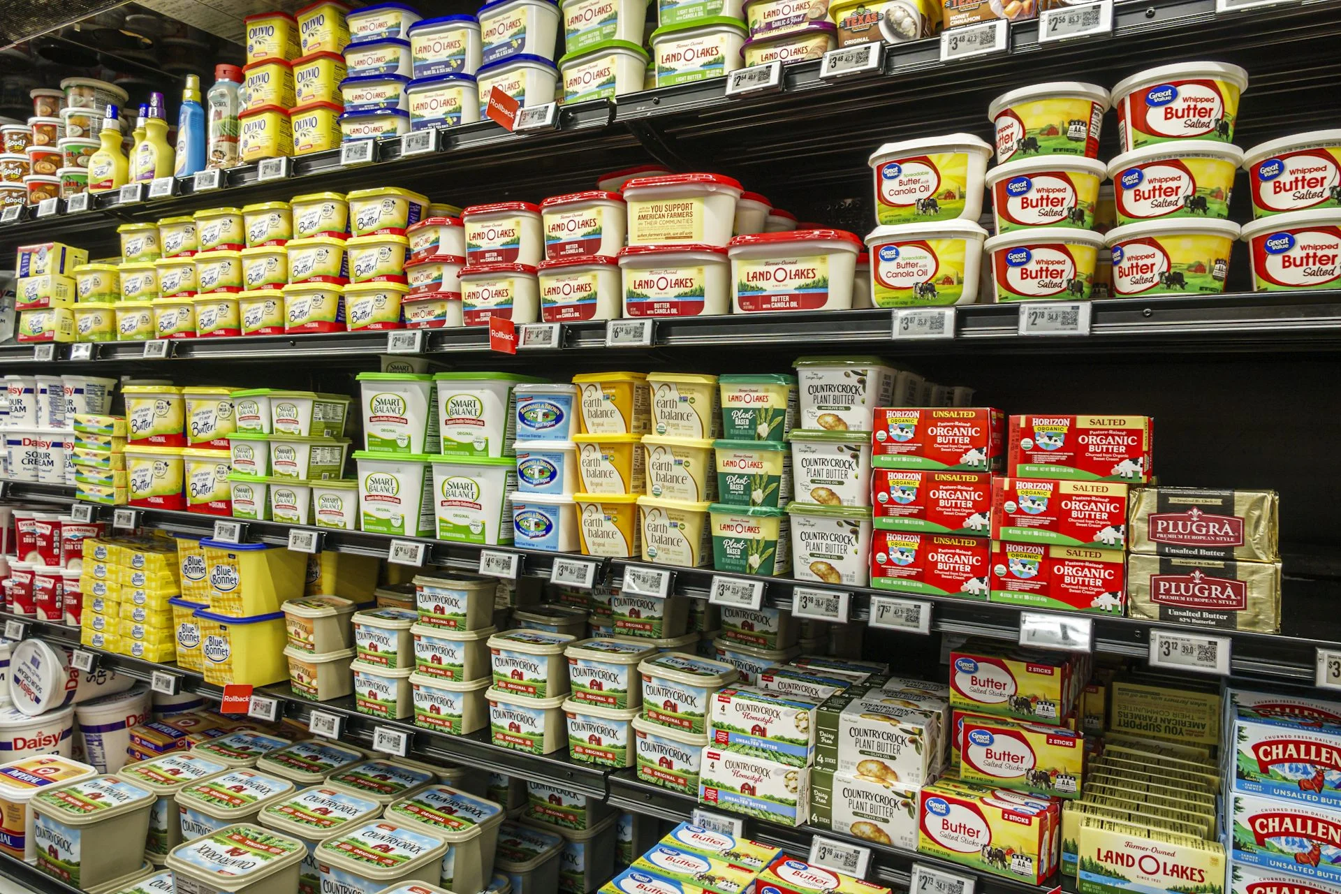 Grocery store shelves stocked with tubs of butter and margarine
