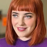 A woman with cropped red hair, smiling.