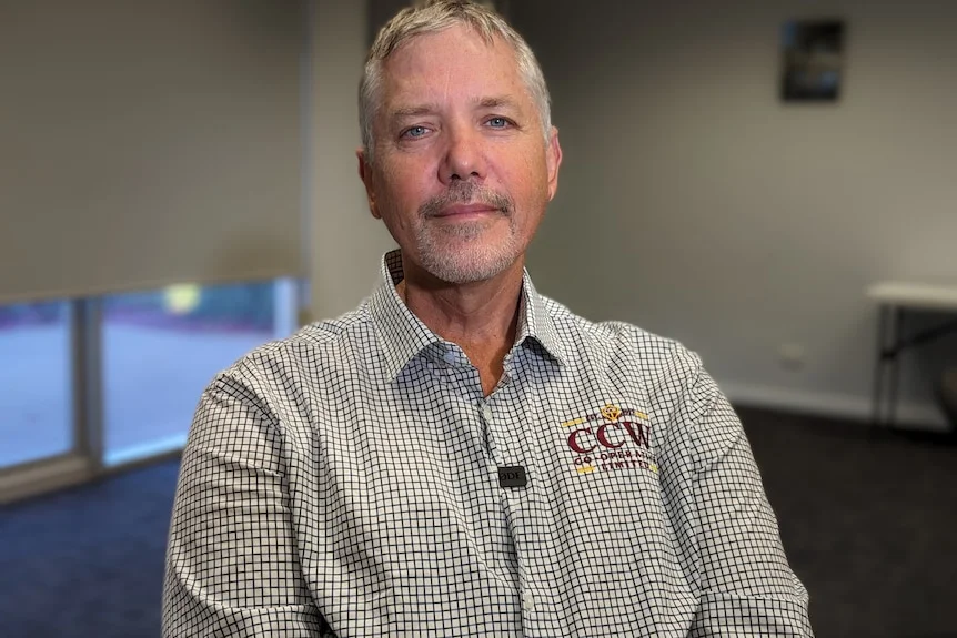 A man with grey hair and a shirt that reads 'CCW' looks at the camera.