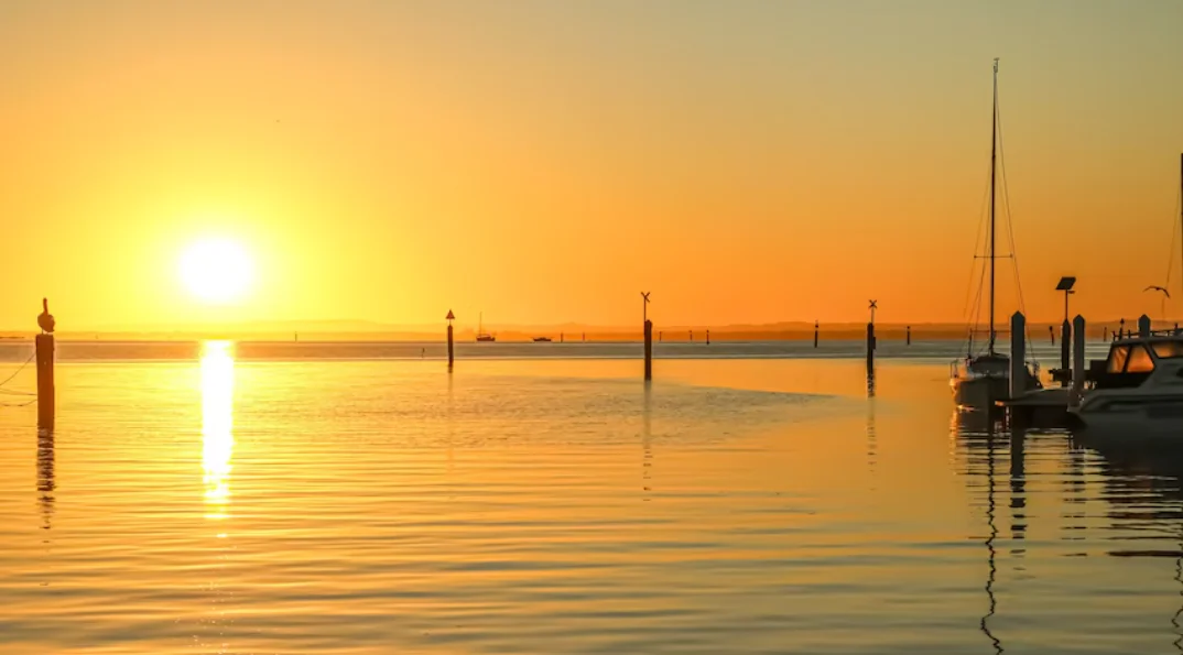 the sun rising over the water