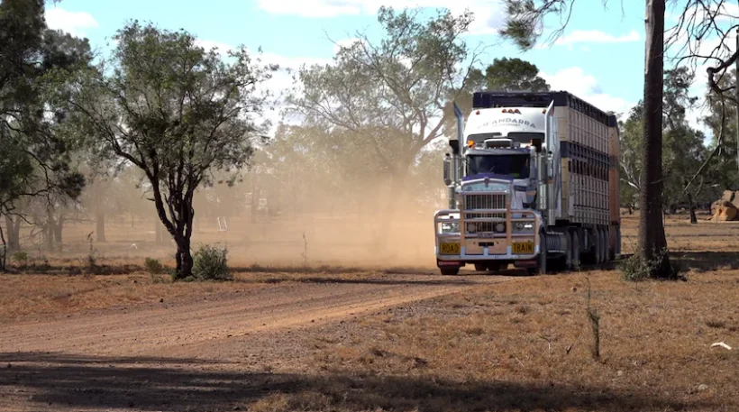 A big truck driving on a dirt road