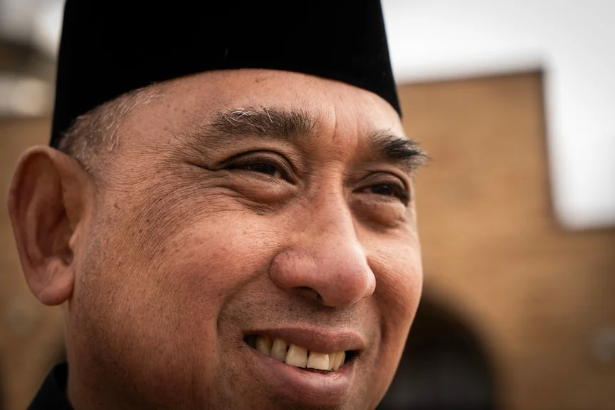 Close-up of a man in front of a mosque