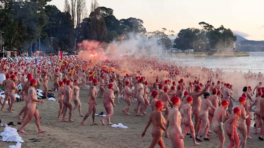 Crowd of swimmers prepare to enter the water for Dark Mofo's 2026 Nude Solstice Swim