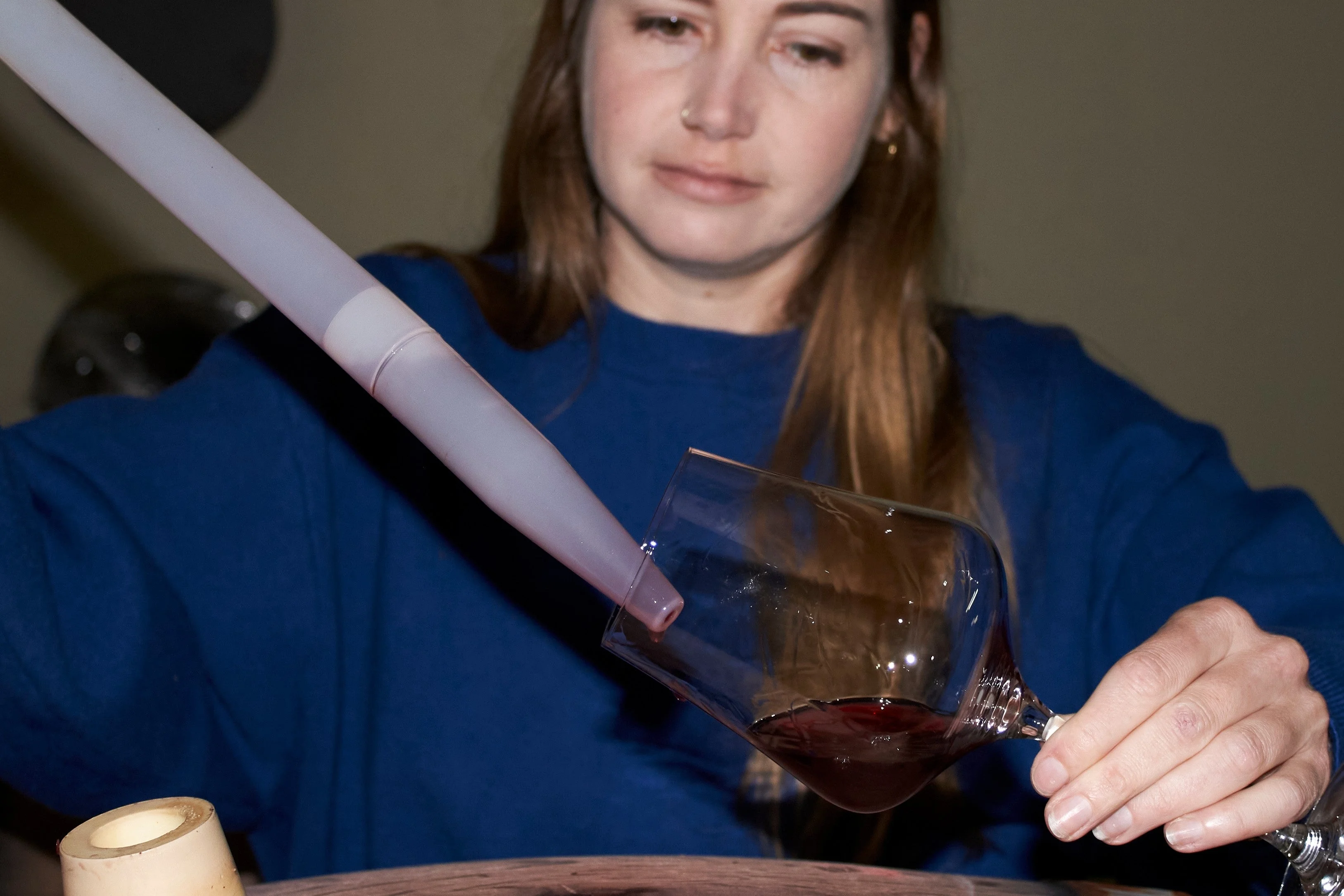 Natasha Jacka pours wine from an oak barrel into a glass using a "wine thief" in Cape Town