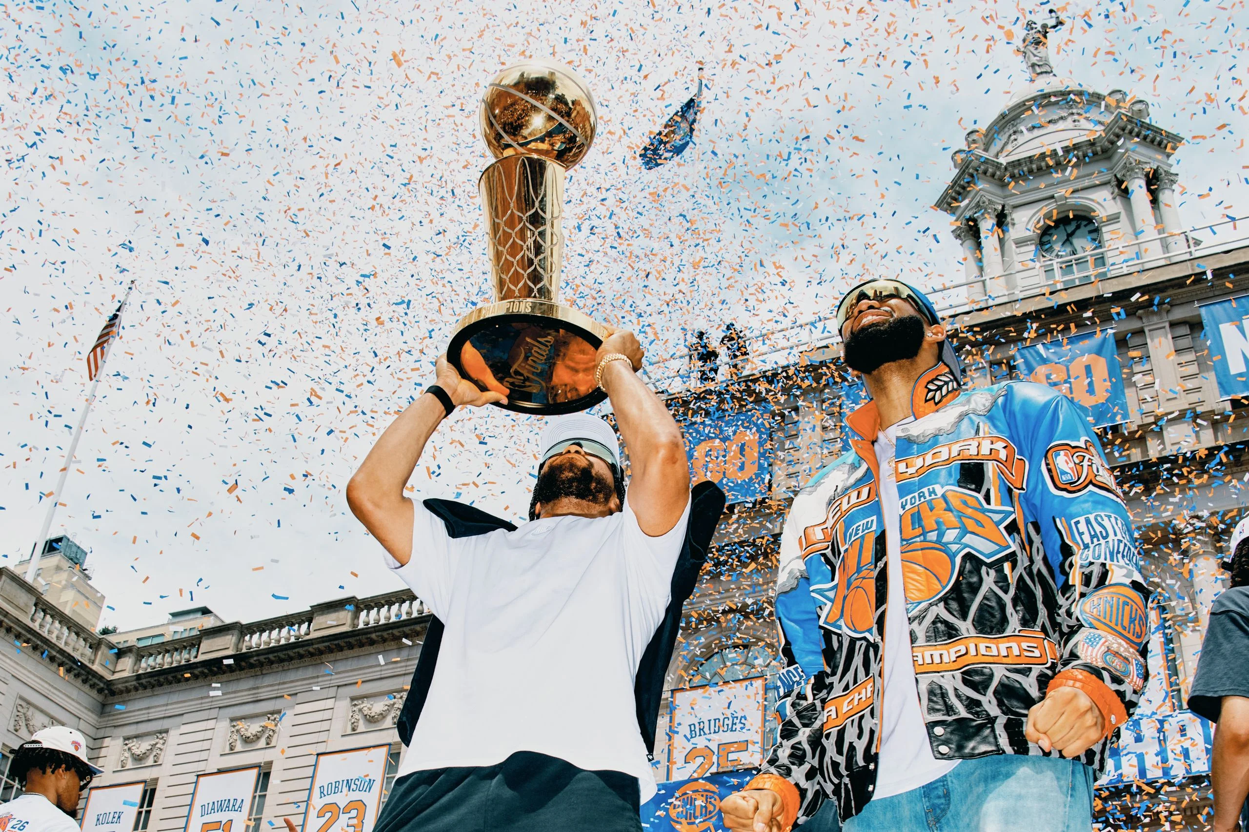 Figures hold trophy in the air