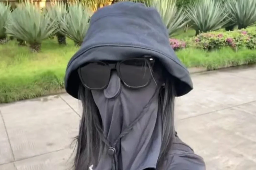 A Chinese woman who took extreme sun protection measures by covering her entire face with a hat and mask after applying sunscreen has developed skin redness and itchiness. Photo: Baidu