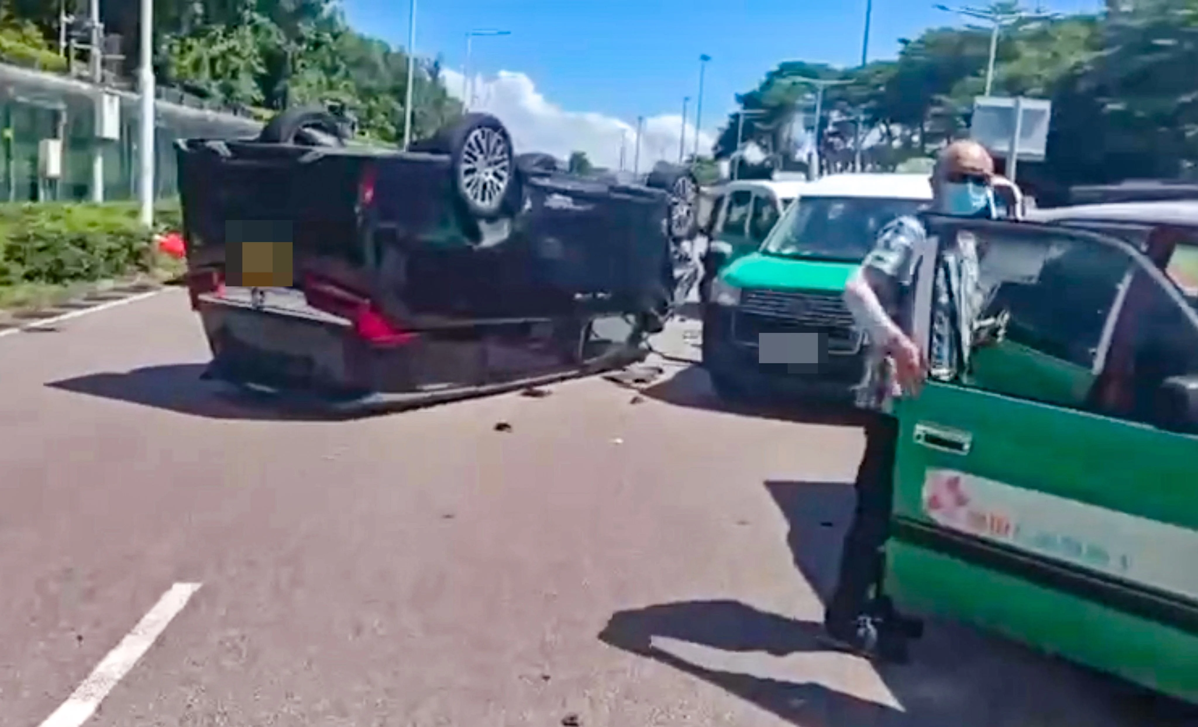 The black seven-seater car lies overturned on the road after colliding with two taxis on Shenzhen Bay Bridge. Photo: Handout