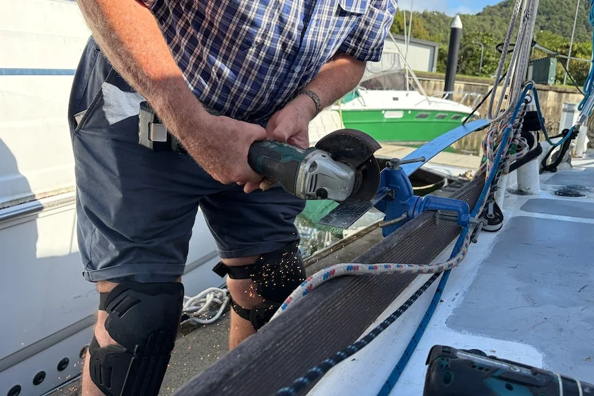 Man using angle grinder on a boat