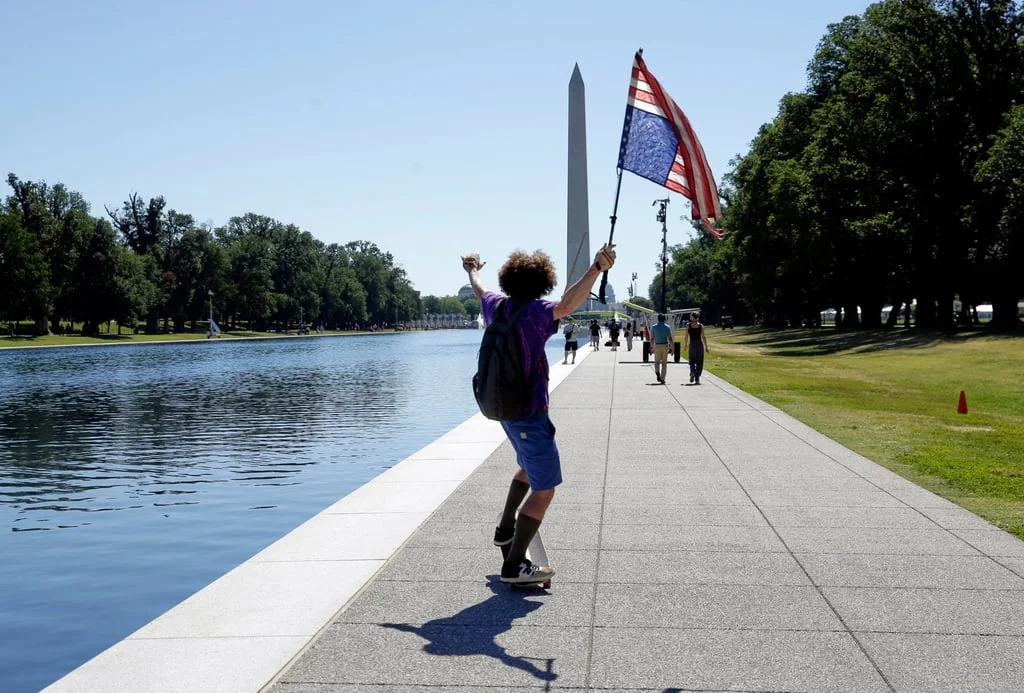 A man with an upside-down US flag is seen near the reflecting pool in Washington on Wednesday. Photo: AP