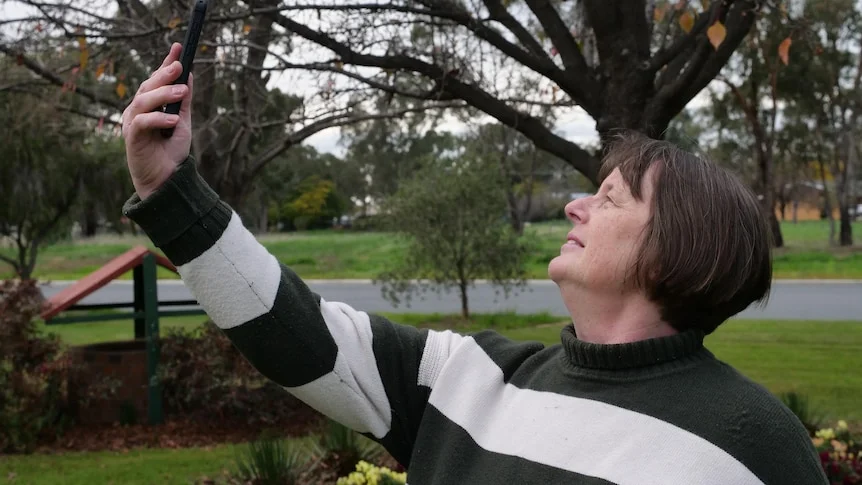 Deb Bewick holds a mobile phone up in search of reception.