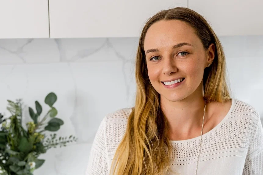 Stacey Warnecke, who died after giving birth at home, smiles for a publicity photo in her kitchen.