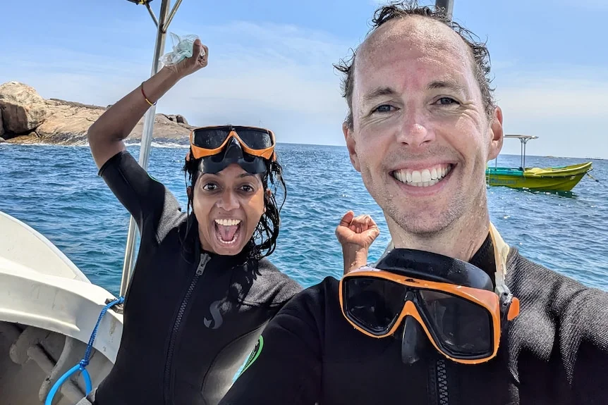 Writer and comedian Sashi Perera and her husband Charlie in wetsuits with scuba masks on a boat in Sri Lanka 