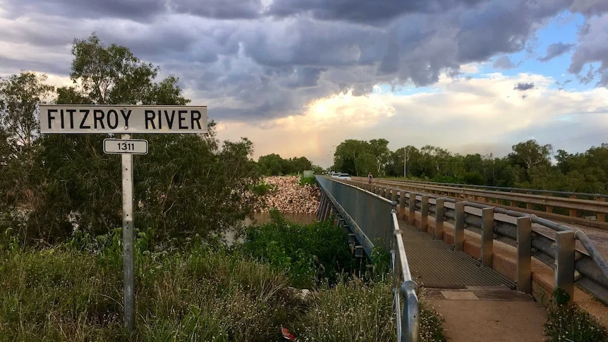 A sign in front of river crossing