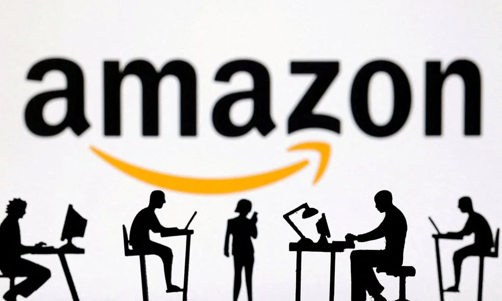 Figurines with computers and smartphones are seen in front of Amazon logo. Photo: Reuters