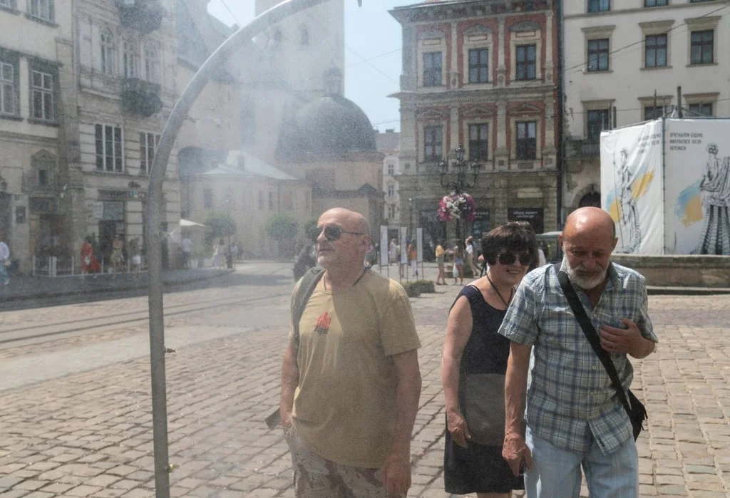 People cool themselves with water from a sprayer set up on a pavement in Lviv, Ukraine, on Monday. Some people in the nation were left without power after the latest Russian strikes, while others turned on air conditioners. Photo: EPA People cool themselves with water from a sprayer set up on a pavement in Lviv, Ukraine, on Monday. Some people in the nation were left without power after the latest Russian strikes, while others turned on air conditioners. Photo: EPA